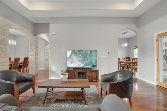 9609 Bluegrass Dr, Austin, TX 78759 - living room featuring arched walkways, wood finished floors, ornate columns, and a high ceiling