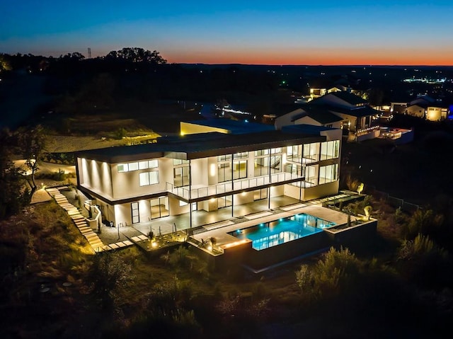 back of property featuring an in ground hot tub, stucco siding, and an outdoor pool