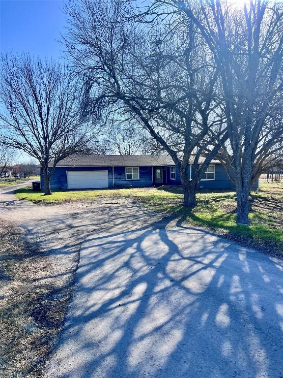 view of front of house with a garage and dirt driveway