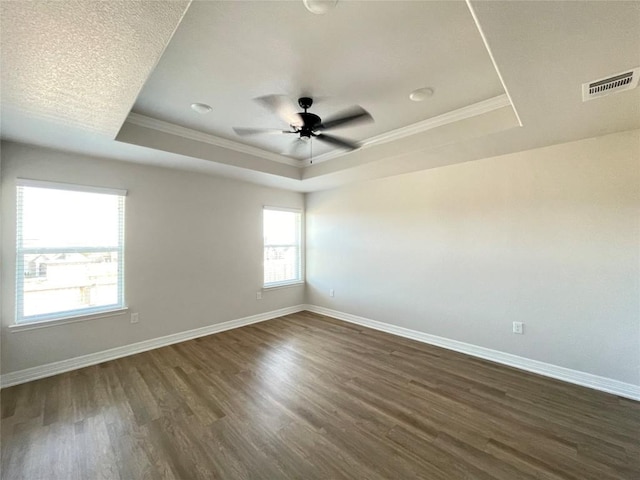 unfurnished room featuring baseboards, a raised ceiling, and dark wood-style flooring