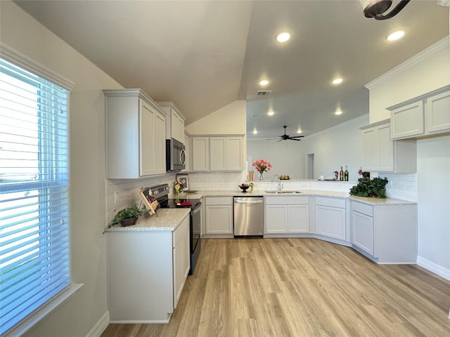 kitchen featuring visible vents, lofted ceiling, appliances with stainless steel finishes, light wood-type flooring, and a sink