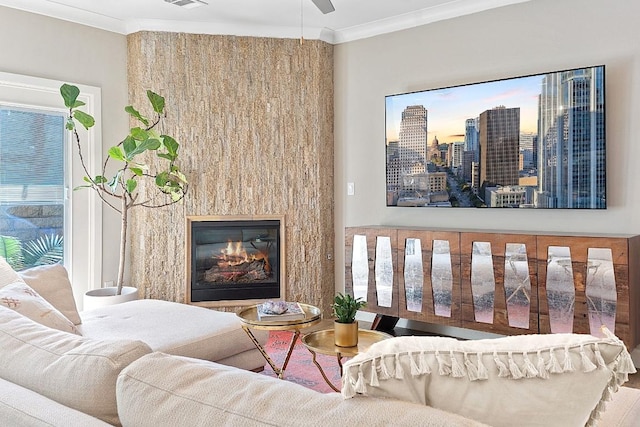 living room with a glass covered fireplace, visible vents, a city view, and ornamental molding