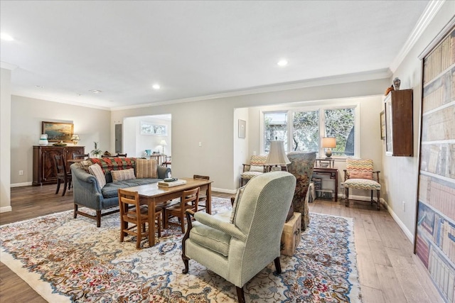 living area featuring light wood-type flooring, crown molding, and baseboards