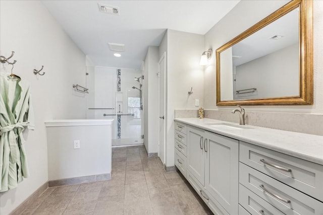 bathroom with a stall shower, baseboards, visible vents, and vanity