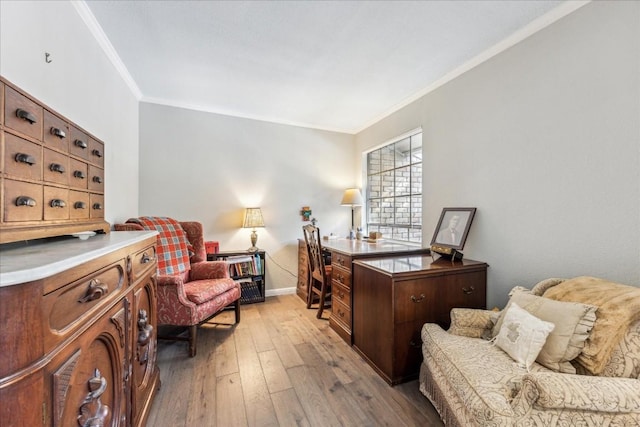 office space featuring baseboards, light wood finished floors, and crown molding