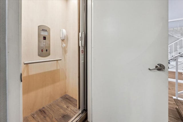 bathroom with elevator and wood finished floors