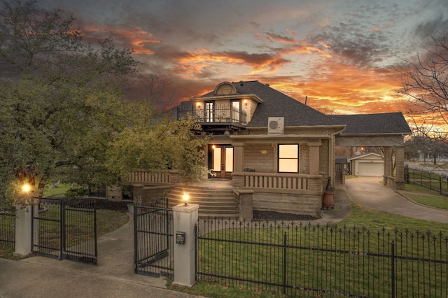 view of front facade featuring a fenced front yard, concrete driveway, a lawn, a balcony, and an outdoor structure