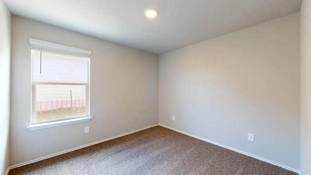 carpeted spare room with baseboards