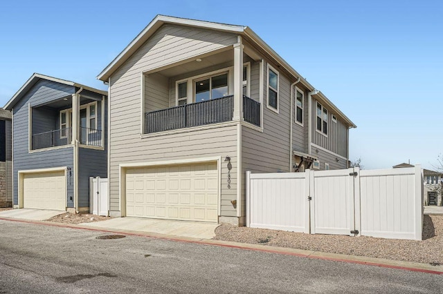 view of front of property with an attached garage, fence, and concrete driveway