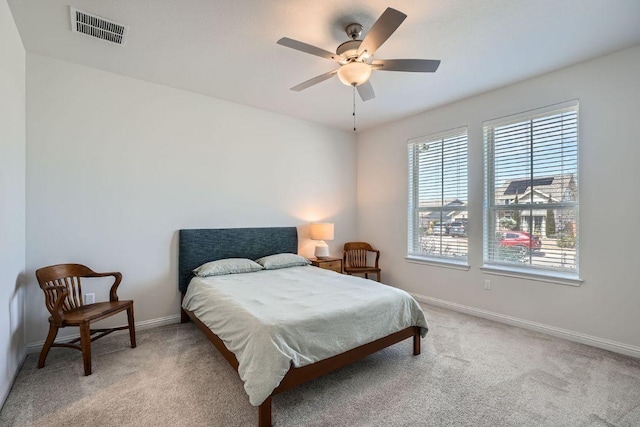 carpeted bedroom featuring ceiling fan, visible vents, and baseboards