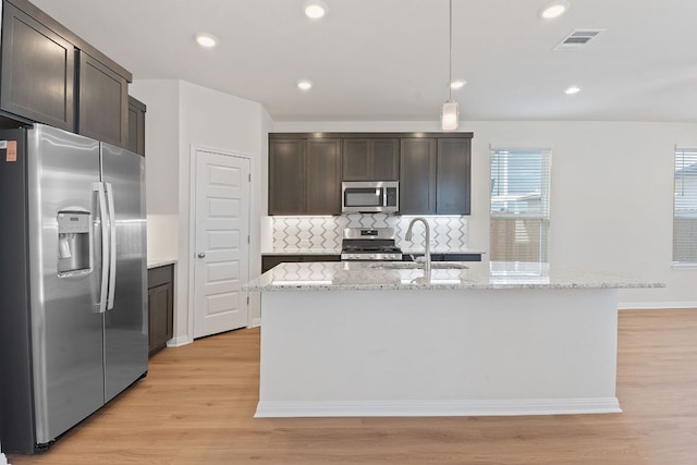 kitchen with light wood-style flooring, dark brown cabinetry, stainless steel appliances, a sink, and visible vents