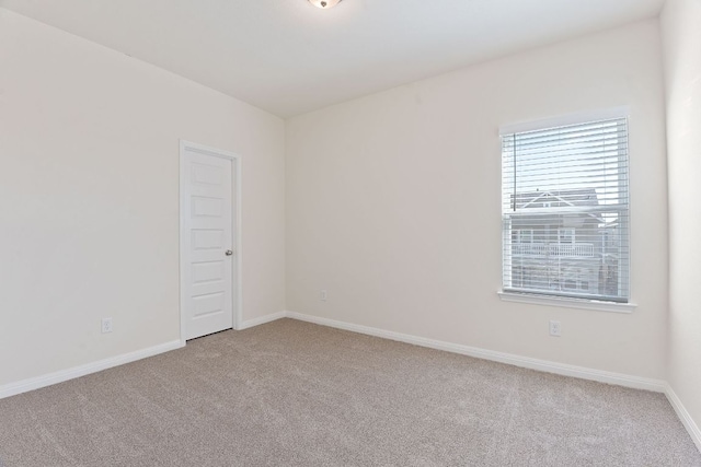 empty room featuring carpet and baseboards