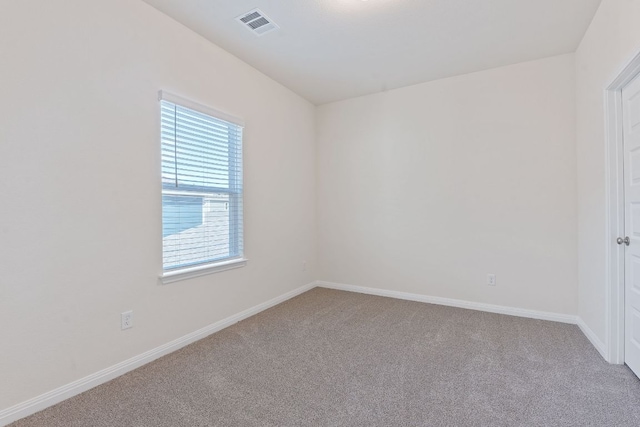 carpeted spare room featuring visible vents and baseboards