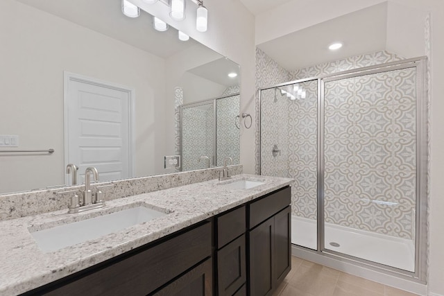 bathroom with double vanity, a sink, and a shower stall