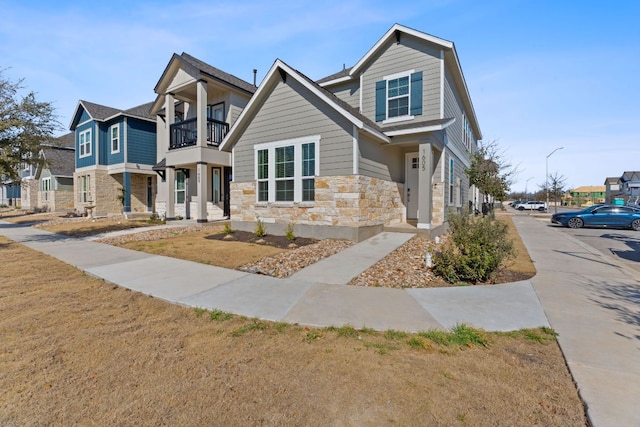 view of front facade featuring a balcony and stone siding