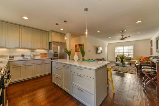 kitchen featuring dark wood-style flooring, stainless steel appliances, visible vents, backsplash, and open floor plan