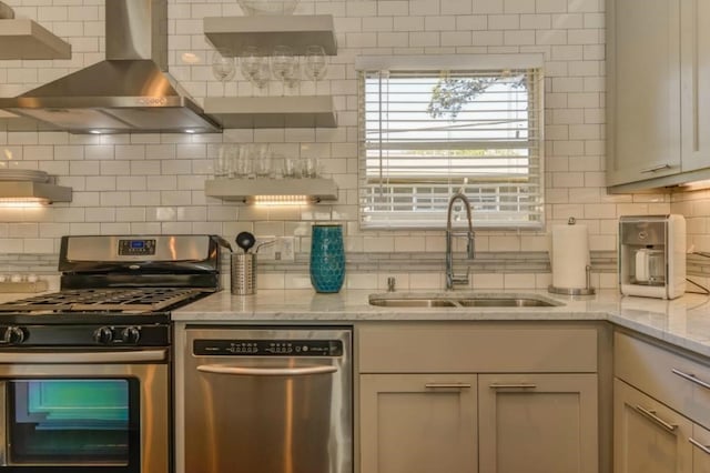 kitchen featuring stainless steel appliances, a sink, wall chimney range hood, open shelves, and tasteful backsplash