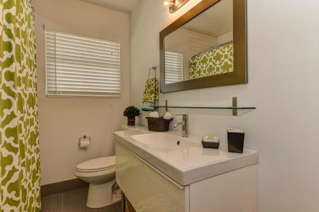 full bathroom featuring toilet, a shower with curtain, baseboards, and vanity