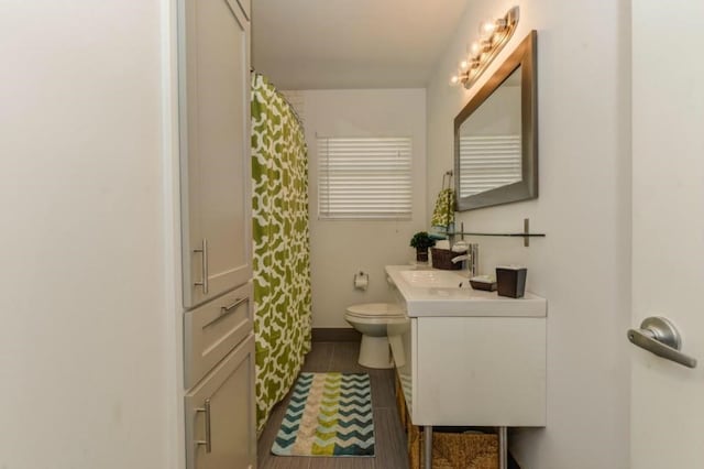 full bathroom featuring toilet, curtained shower, baseboards, and vanity