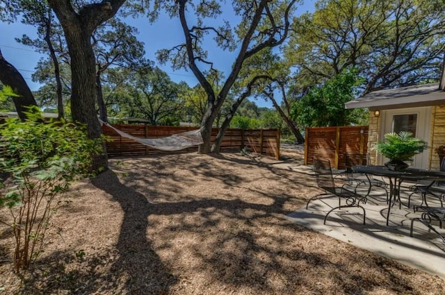 view of yard with outdoor dining space, fence, and a patio