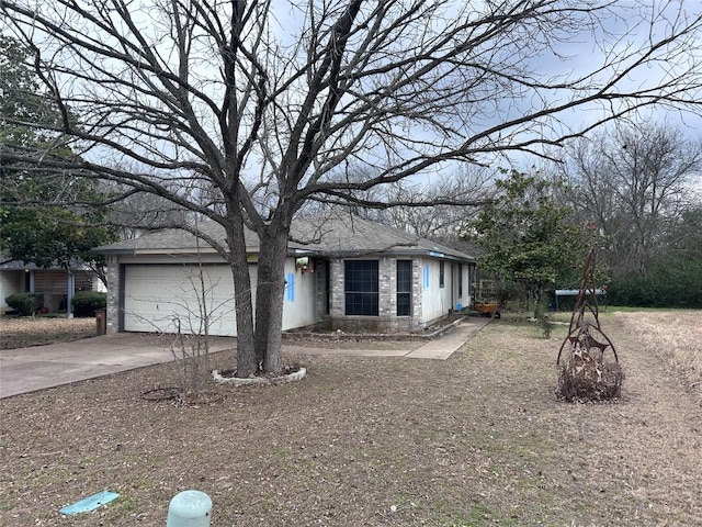 view of front of house featuring stone siding, driveway, and an attached garage