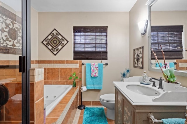 full bath with toilet, vanity, a jetted tub, and tile patterned floors