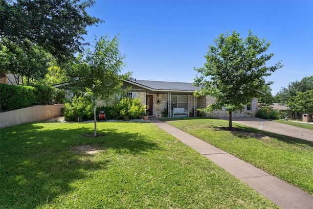 view of front of property with driveway, stone siding, and a front lawn