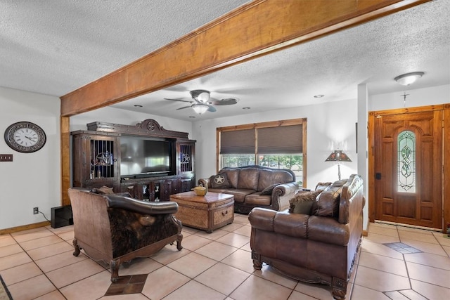 living area with light tile patterned floors, ceiling fan, and a textured ceiling