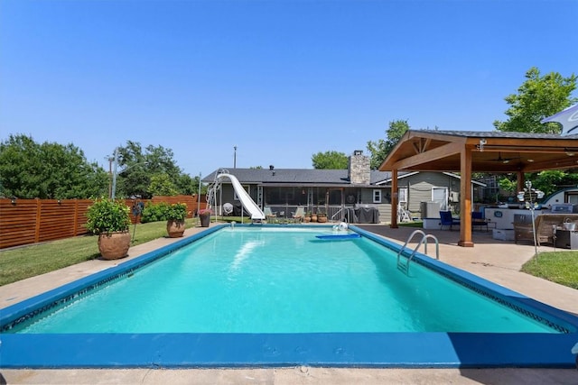 view of swimming pool featuring a water slide, a patio area, a fenced backyard, and a fenced in pool