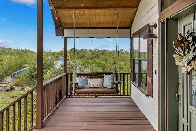 wooden terrace featuring a wooded view