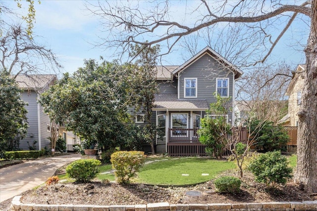 view of front of property featuring a front yard, driveway, and fence