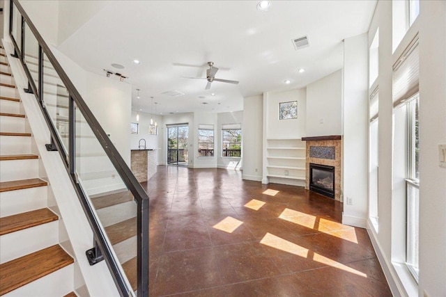 entryway featuring stairway, baseboards, visible vents, and a glass covered fireplace