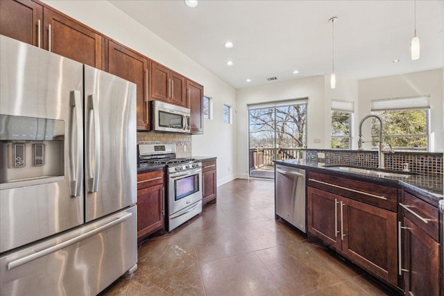 kitchen featuring recessed lighting, stainless steel appliances, a sink, tasteful backsplash, and pendant lighting