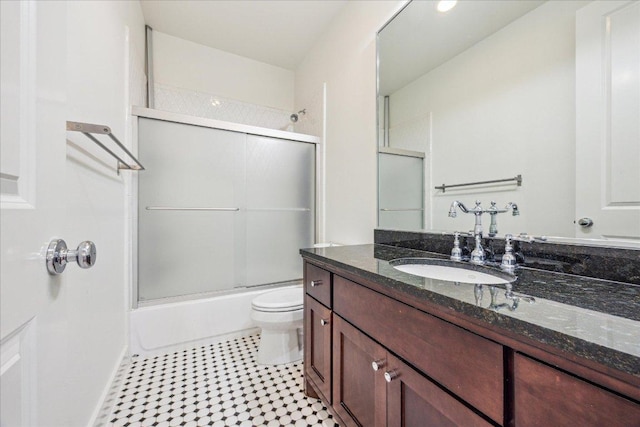 full bath featuring toilet, tile patterned floors, enclosed tub / shower combo, and vanity