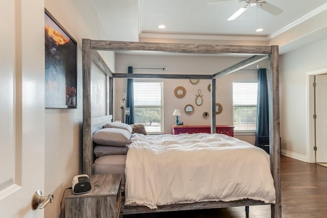 bedroom featuring crown molding, multiple windows, baseboards, and wood finished floors