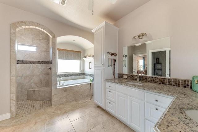 full bathroom featuring tasteful backsplash, a walk in shower, a bath, and vanity