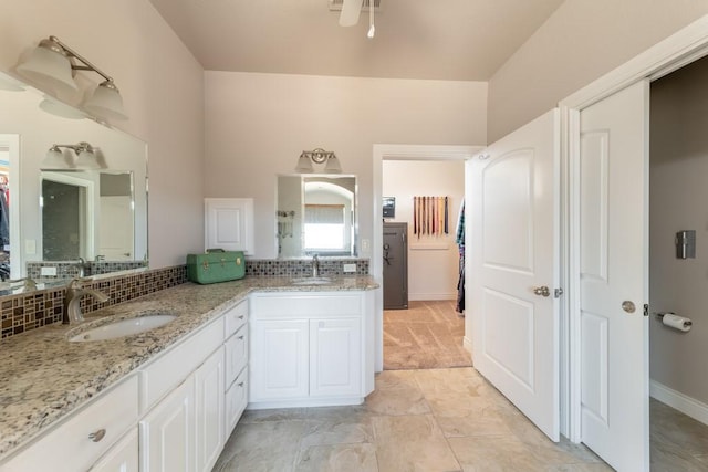 full bathroom with double vanity, a closet, a sink, and decorative backsplash