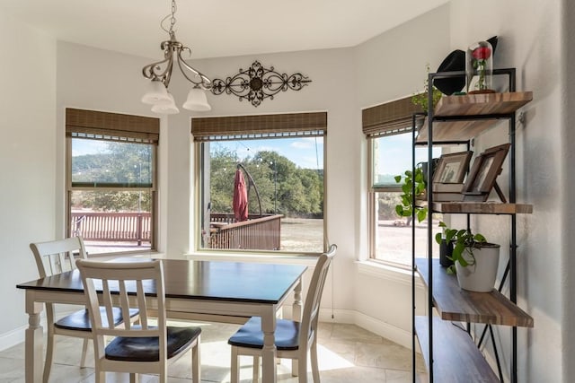 dining space with baseboards and a notable chandelier