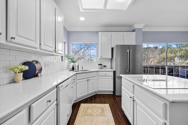 kitchen featuring a sink, white cabinetry, ornamental molding, freestanding refrigerator, and dishwasher