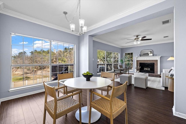 dining room featuring a fireplace, crown molding, visible vents, dark wood-type flooring, and baseboards