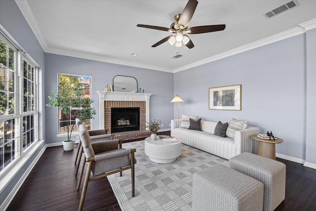 living room with baseboards, visible vents, ornamental molding, wood finished floors, and a fireplace