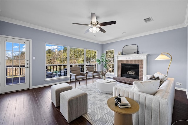 living room featuring a wealth of natural light, crown molding, baseboards, and wood finished floors