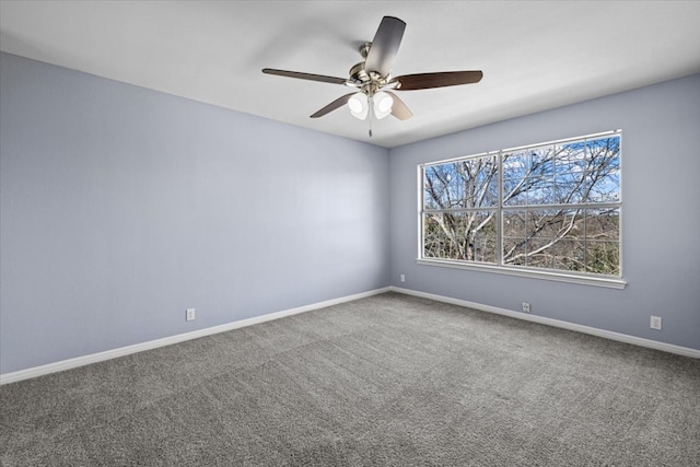 carpeted spare room with baseboards and a ceiling fan