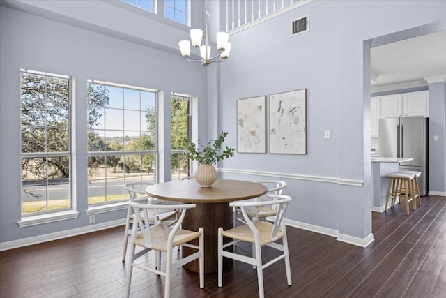 dining area featuring crown molding, a healthy amount of sunlight, visible vents, and a notable chandelier