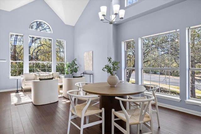 dining space featuring an inviting chandelier, plenty of natural light, high vaulted ceiling, and dark wood-type flooring