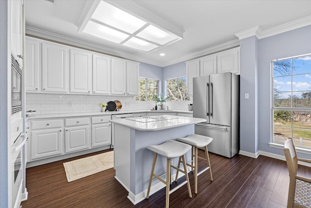 kitchen featuring ornamental molding, white appliances, light countertops, and dark wood-style flooring