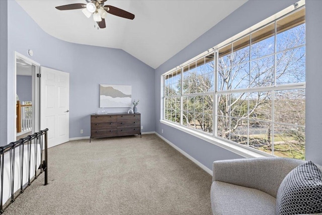 living area with a ceiling fan, carpet flooring, vaulted ceiling, and baseboards