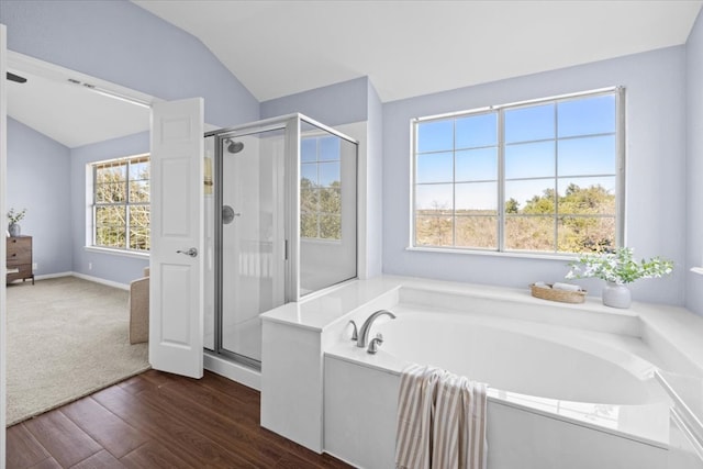 full bathroom featuring lofted ceiling, a stall shower, wood finished floors, and a garden tub