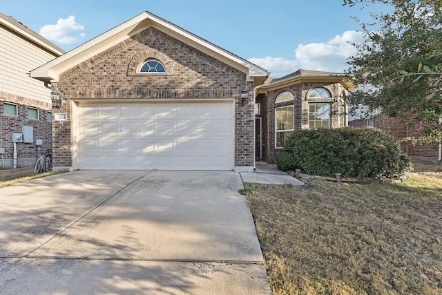 single story home with concrete driveway, a garage, and brick siding