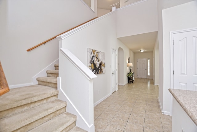 stairway with baseboards and tile patterned floors